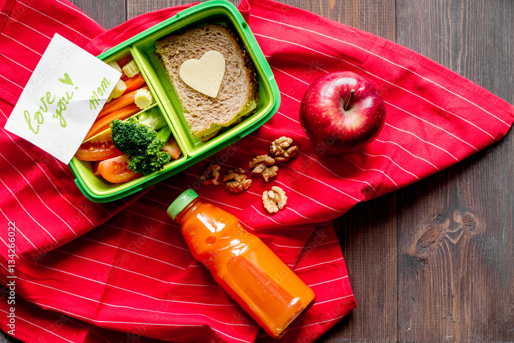 green lunch box for kid on wooden background top view