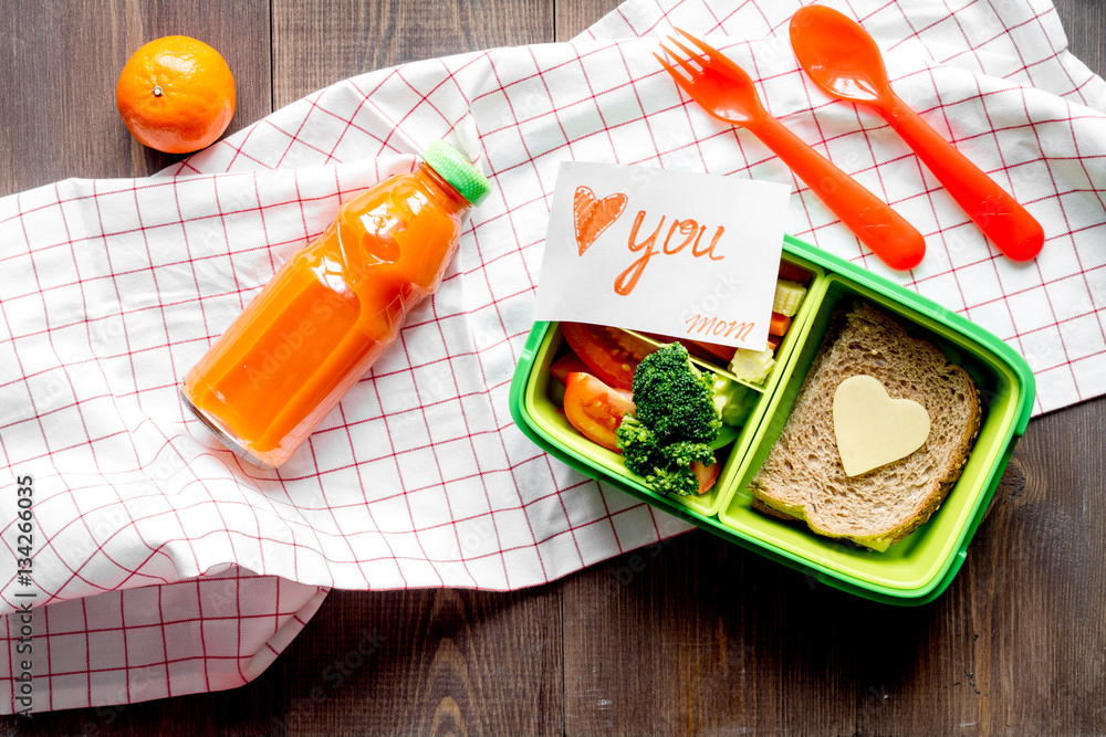 green lunch box for kid on wooden background top view