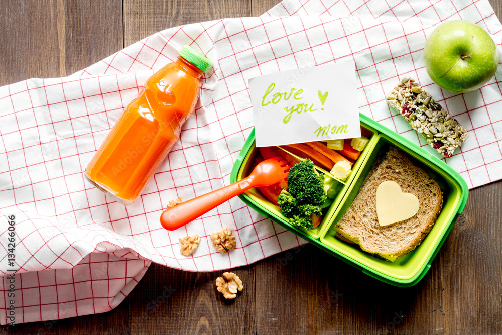 green lunch box for kid on wooden background top view