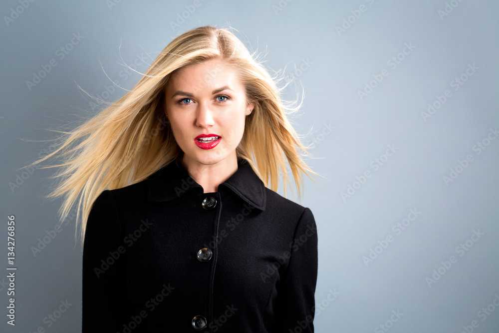 Beautiful blonde woman in a black coat