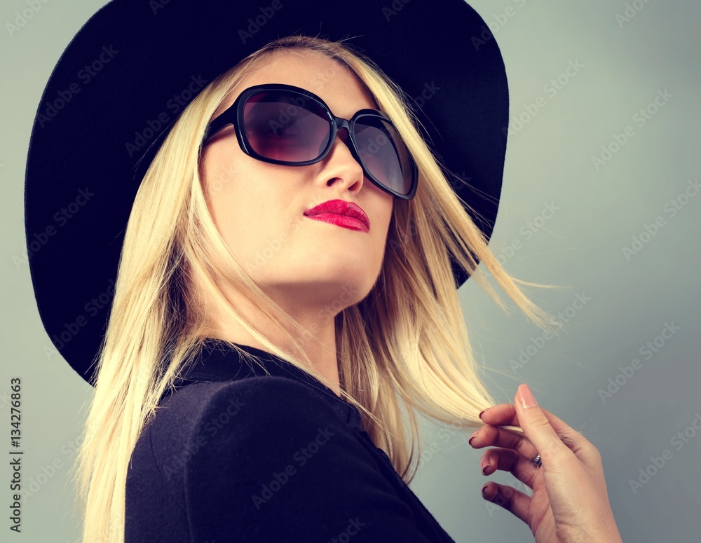 Beautiful young blonde woman in a black coat