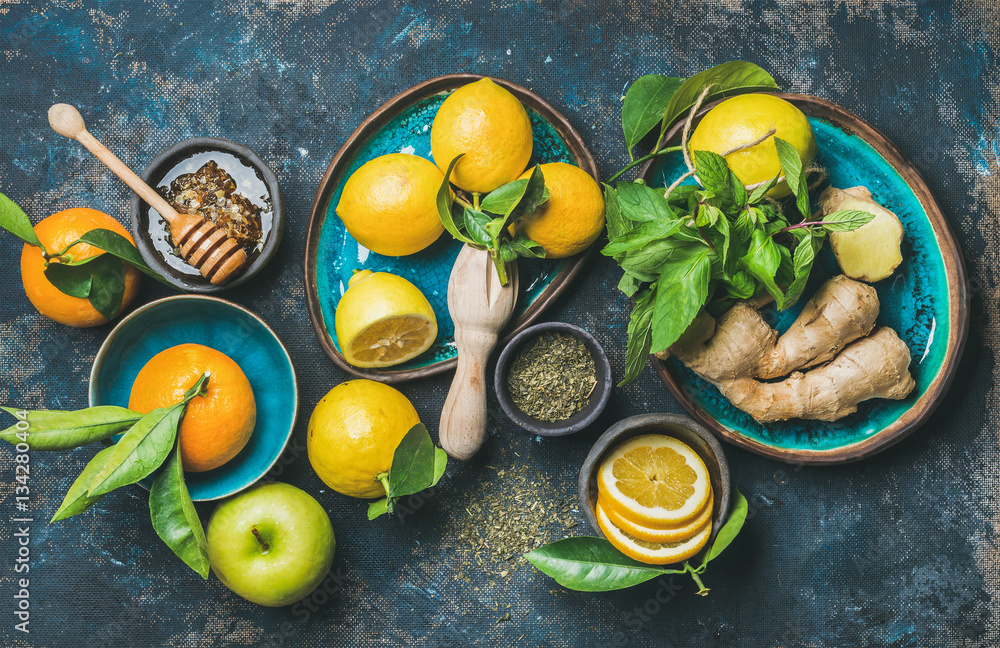 Ingredients for making natural hot drink in blue ceramic plates over dark blue shabby background, to