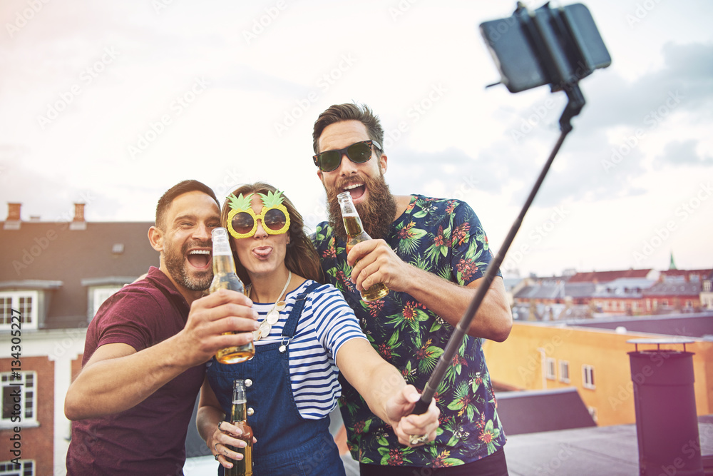 Group of three adults drinking and taking pictures