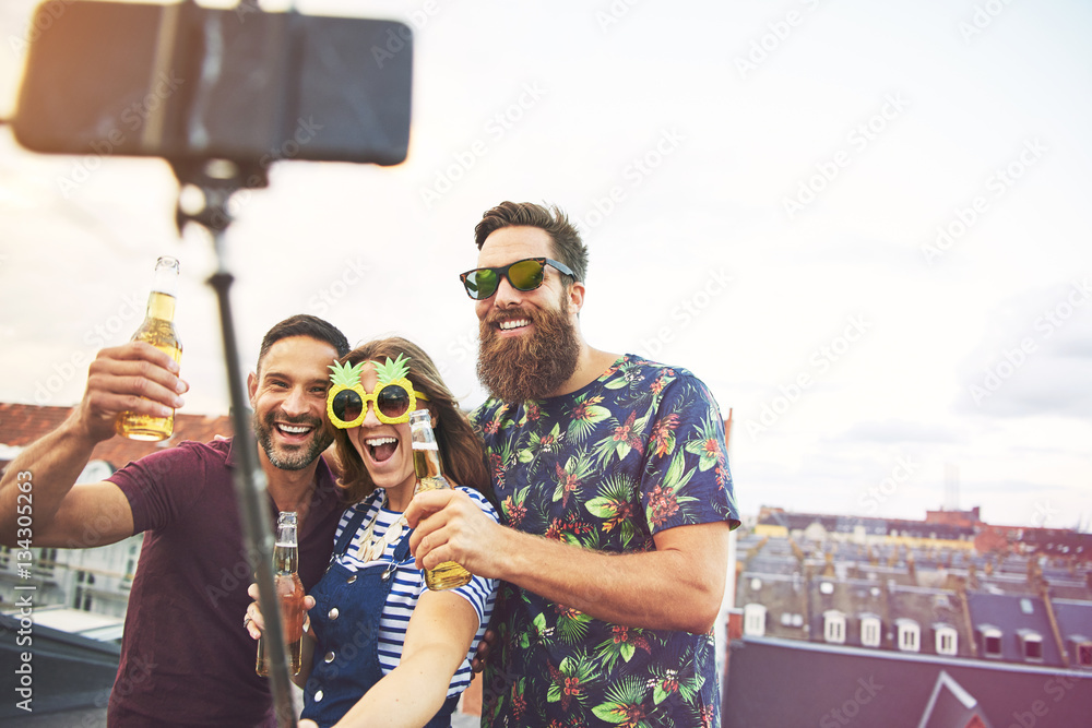 Three inebriated friends taking pictures on roof