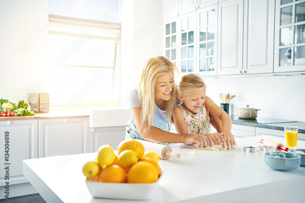 Young mother and daughter baking together