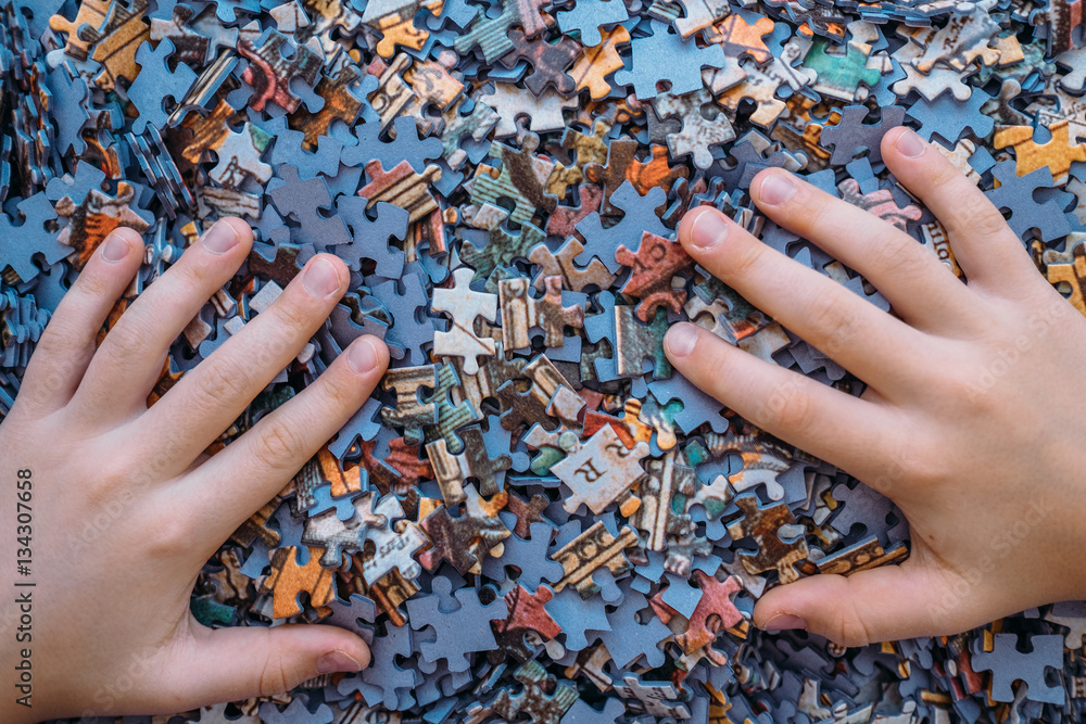 Childrens hands on Jigsaw puzzle color background