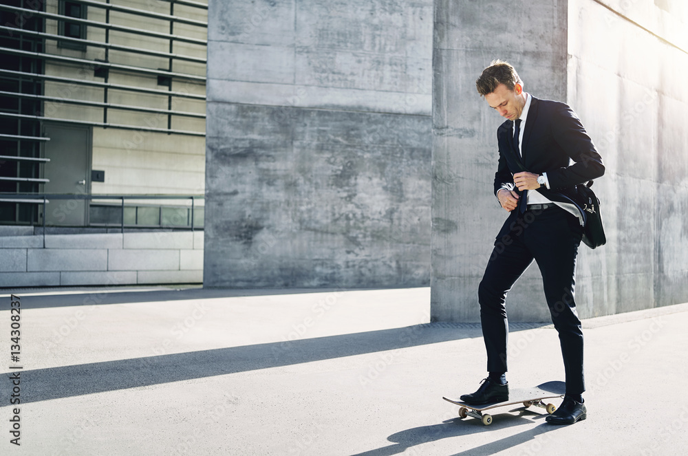 Businessman adjusting his necktie standing on skateboard