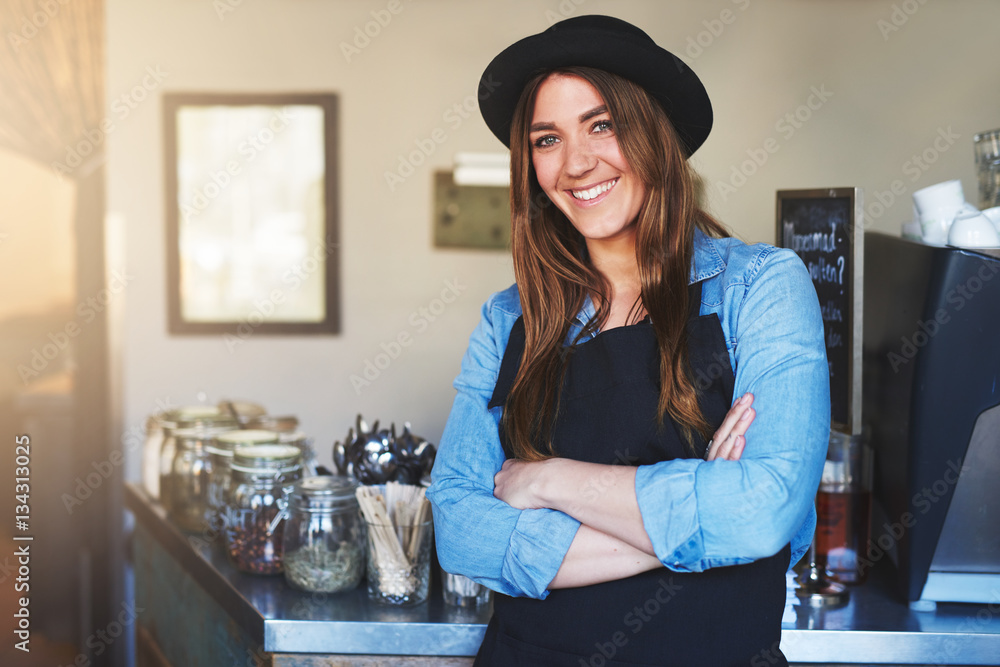 Young female smiling staff posing in cafe