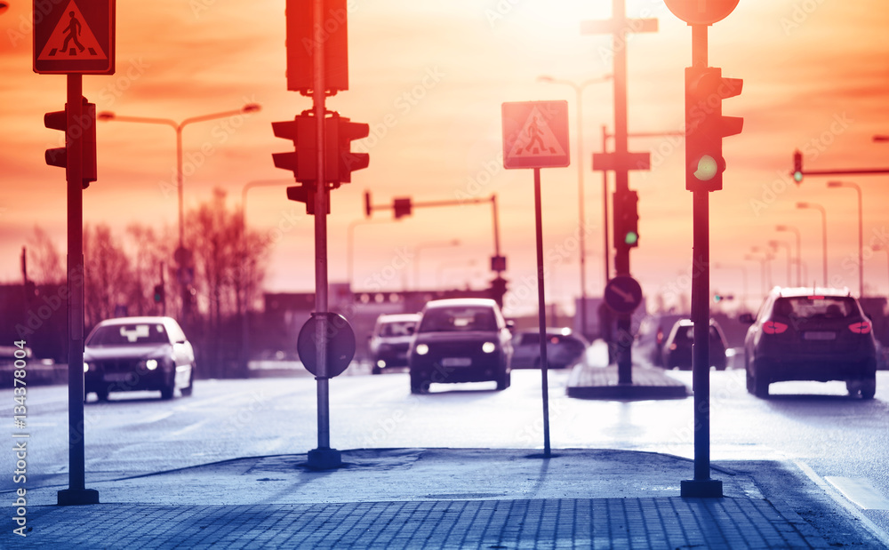 Cars moving on the road in city in early morning. View to the traffic with trafficlights and transpo