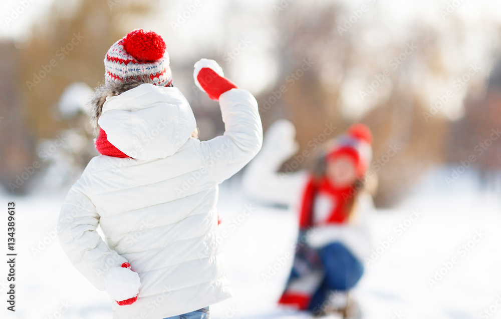 happy family mother and child playing snowballs on winter walk