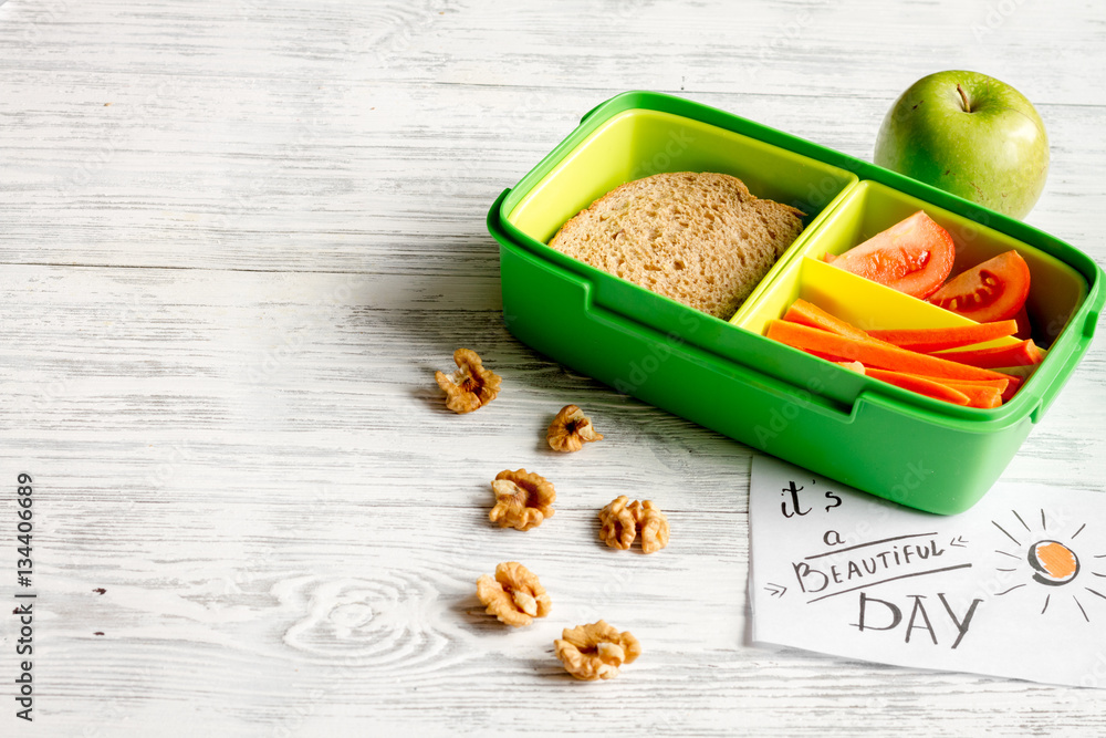 lunch box for kid with fresh vegetables on wooden background