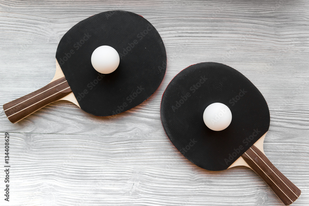 black racket for ping pong ball wooden background top view