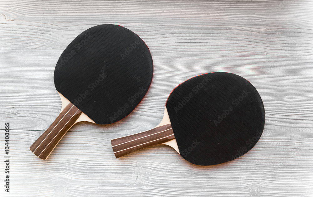 black racket for ping pong ball wooden background top view