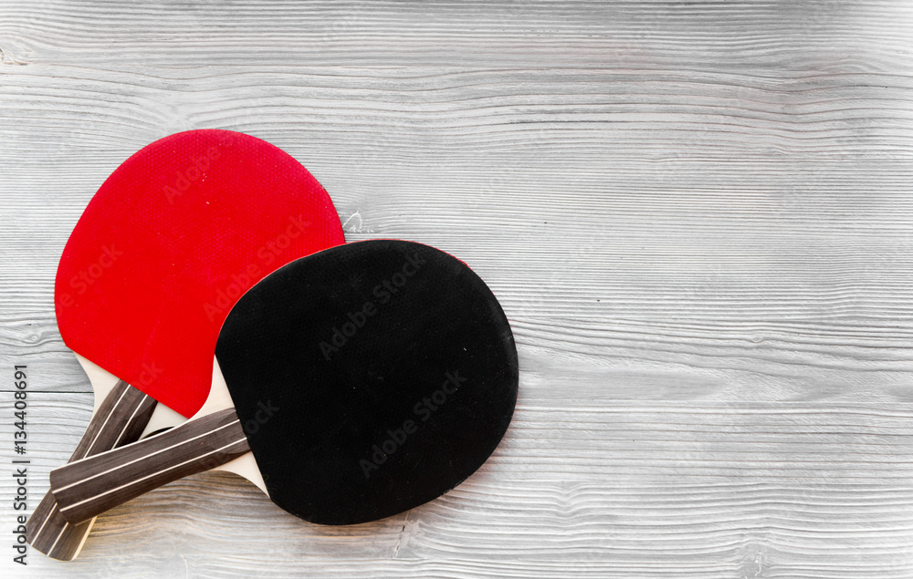 black racket for ping pong ball wooden background top view