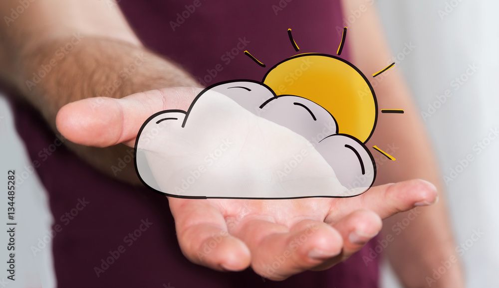 Man holding hand drawn cloud and sun icons