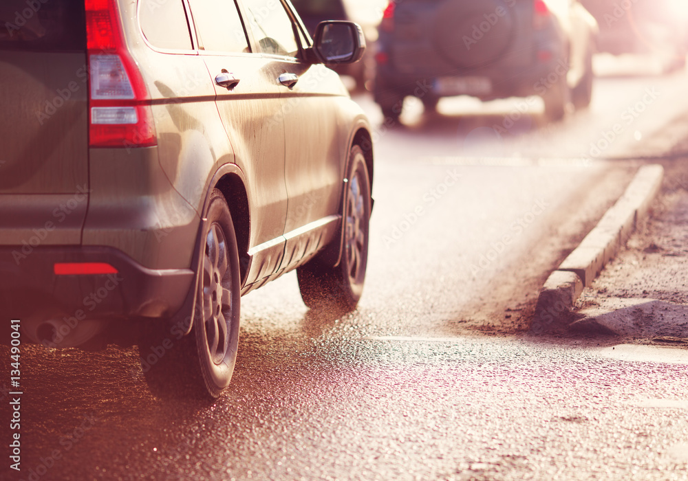 Cars moving on the road in city in early morning. View to the traffic and transport