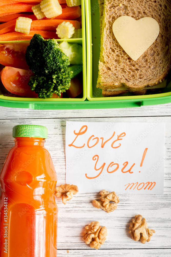 green lunch box for kid on wooden background top view