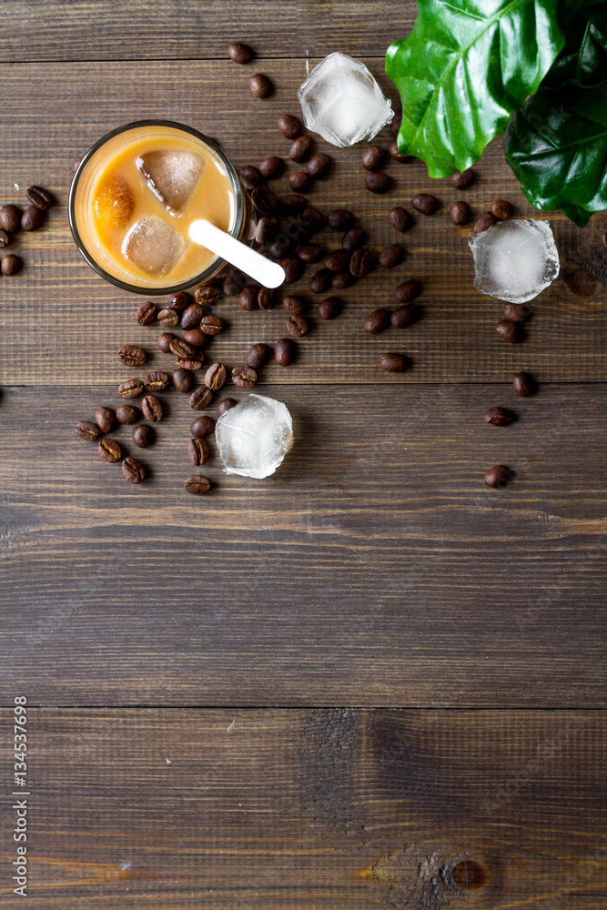 coffee with ice in glass on wooden background top view