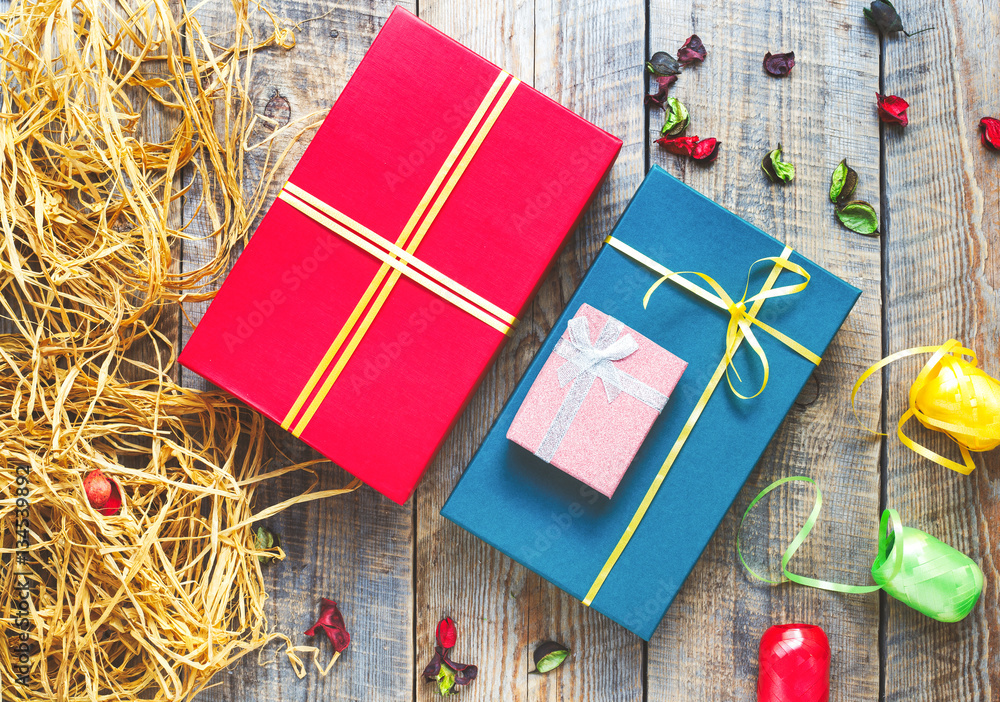 Colored gift boxes on wooden background with ribbons