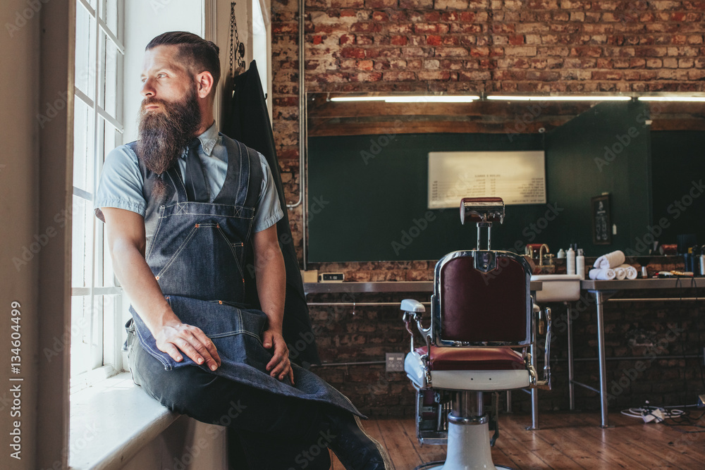 Young barber at his barbershop