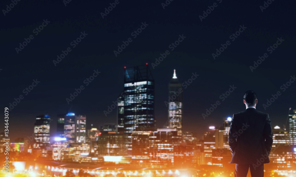 Businessman viewing night glowing city