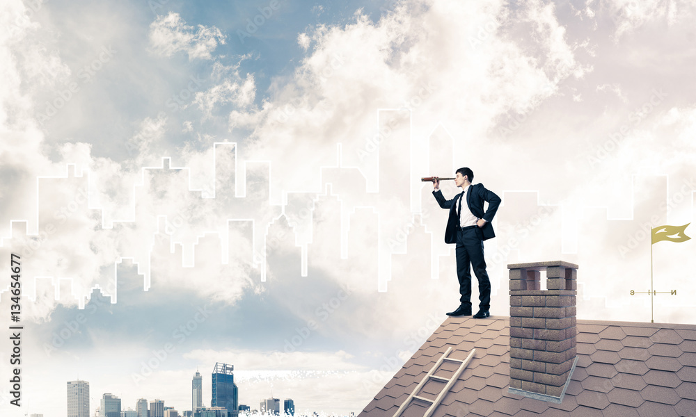 Engineer man standing on roof and looking in spyglass. Mixed med