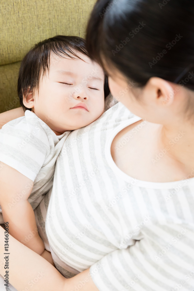 asian mother and baby relaxing on the sofa