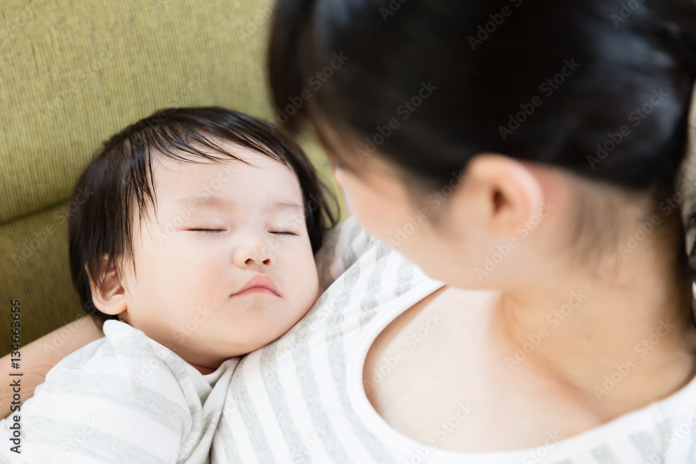 asian mother and baby relaxing on the sofa