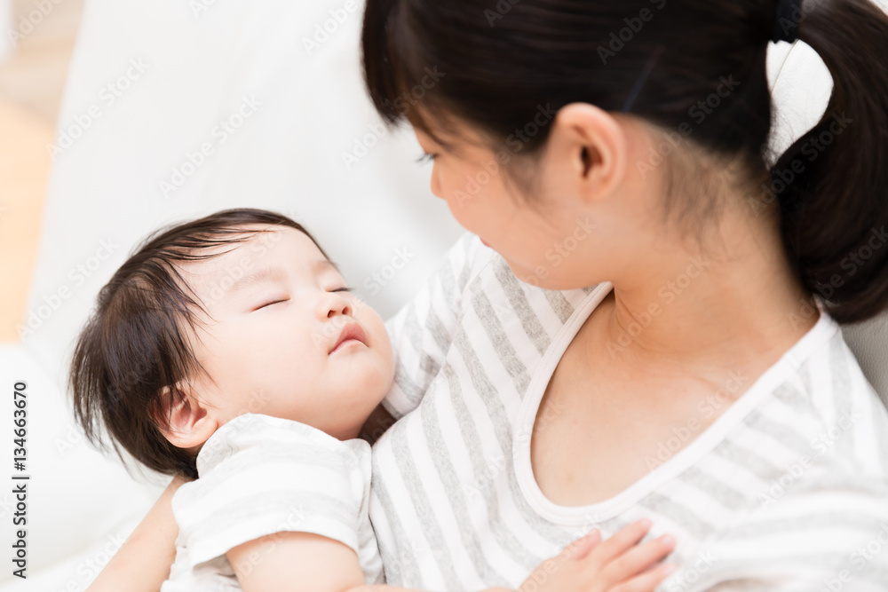 asian mother and baby relaxing on the sofa