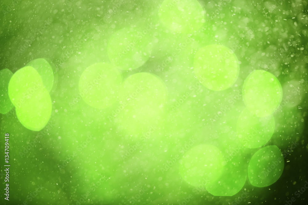 Beautiful blurred green colored abstract bokeh light with raindrops background.