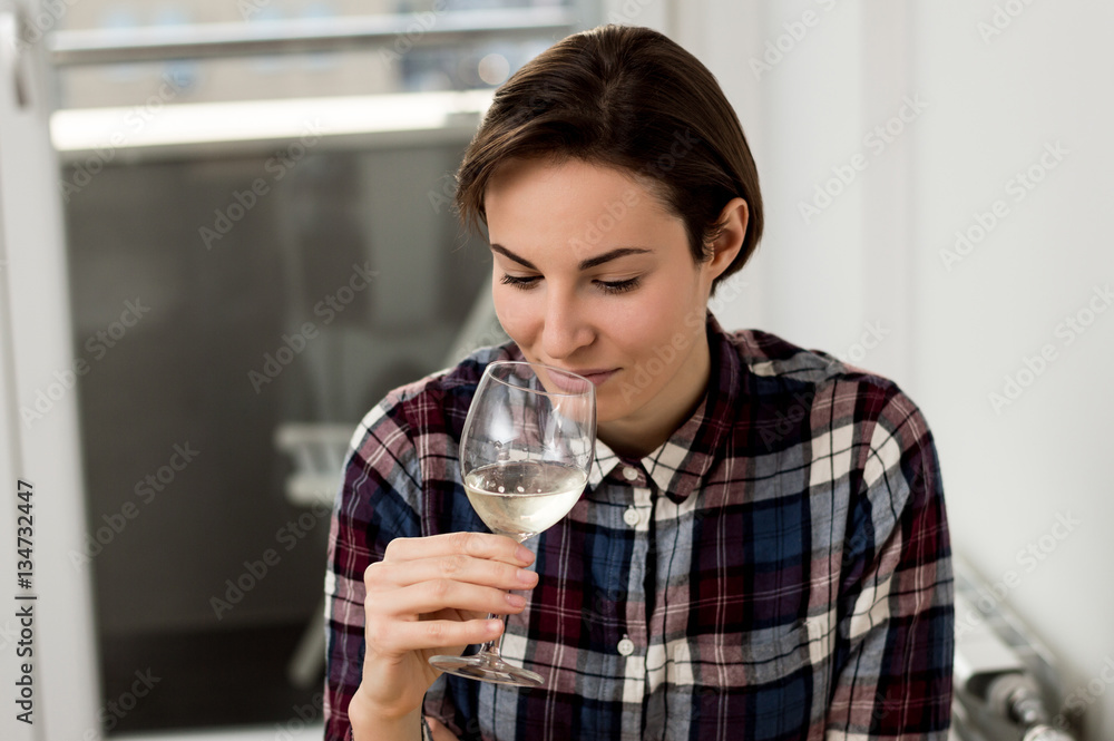 Pretty woman drinking some wine at home