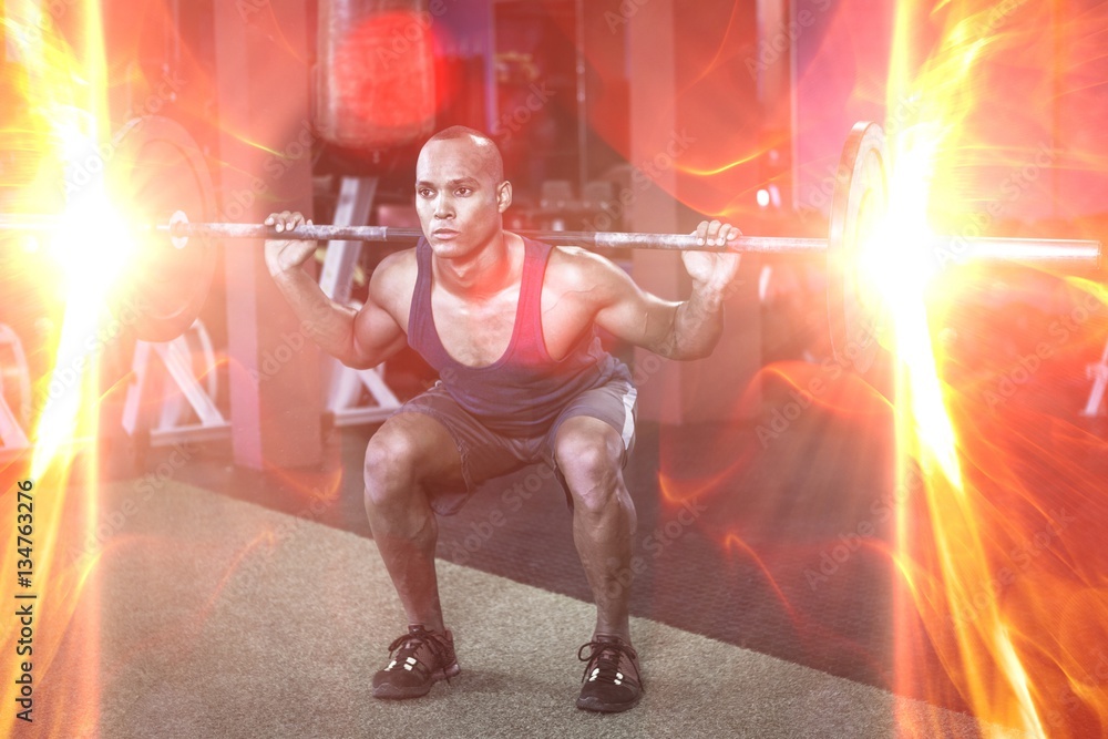 Young man weightlifting in fitness studio