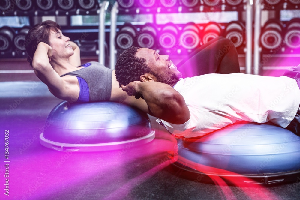 Fit couple doing bosu ball exercises 