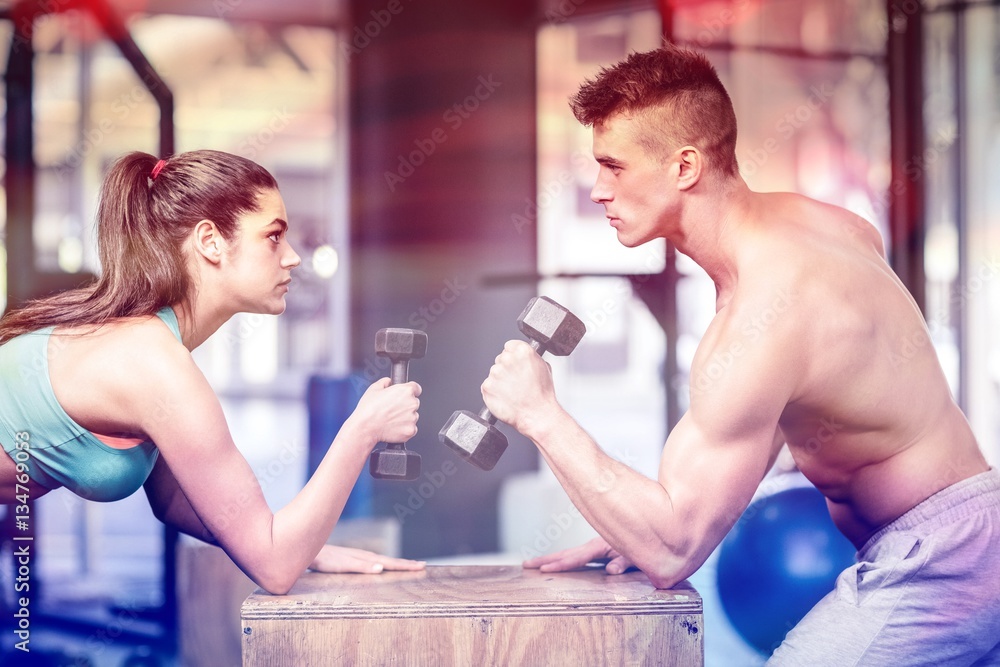 Fit couple lifting dumbbells