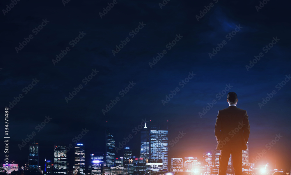 Businessman viewing night glowing city