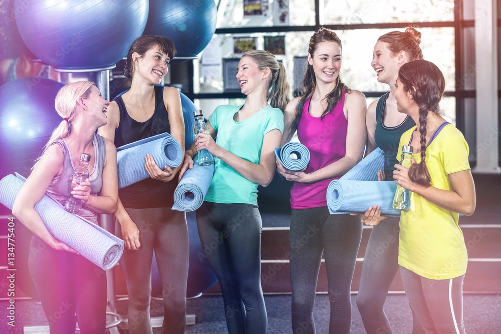 Woman chatting before yoga class while carrying mat