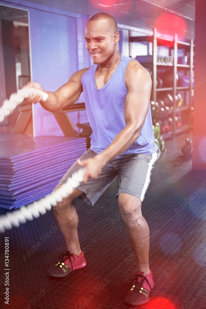 Athlete exercising with ropes in fitness studio