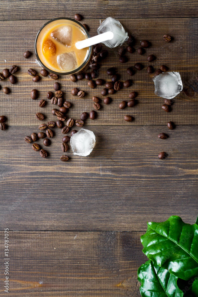 coffee with ice in glass on wooden background top view