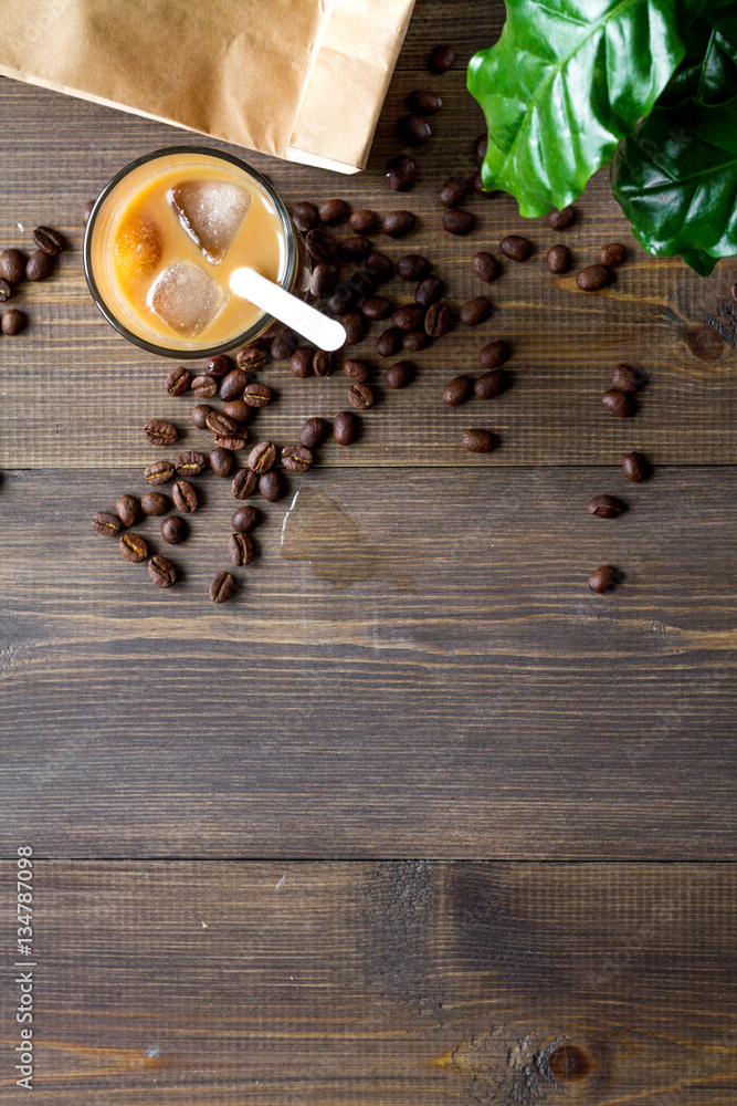 coffee with ice in glass on wooden background top view