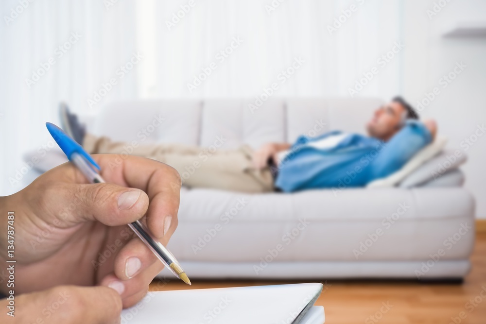 Composite image of close up of man writing in notepad