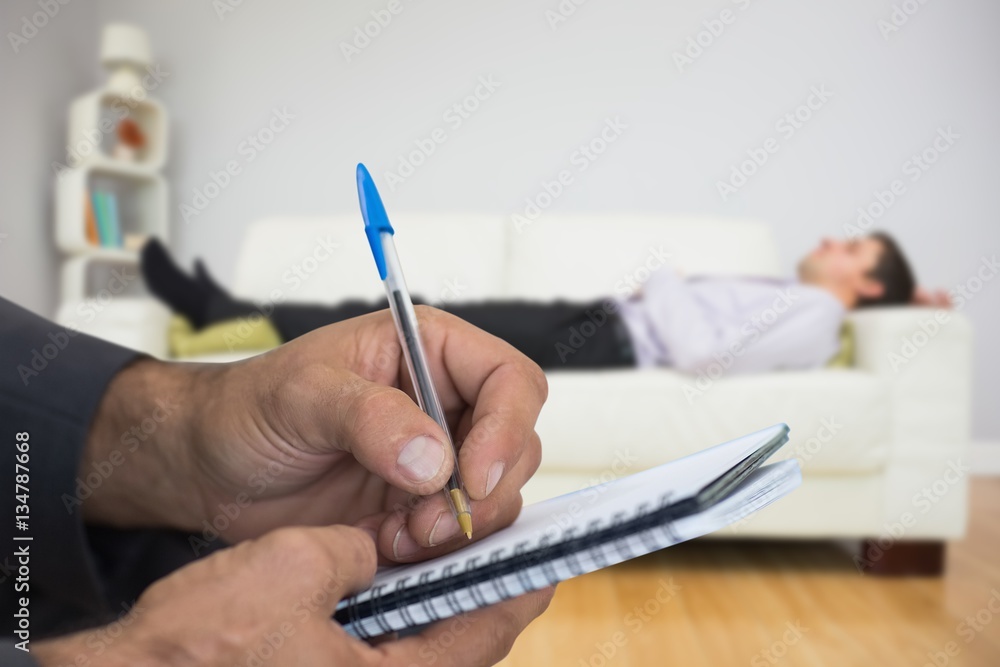 Composite image of close up of man writing in spiral book