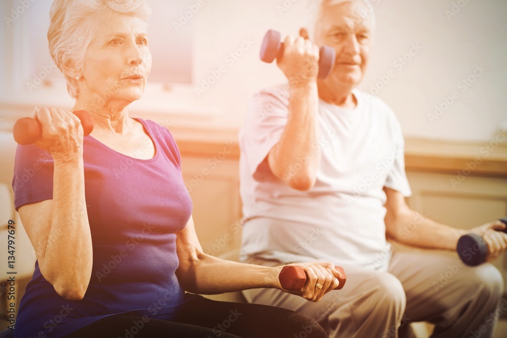 Senior couple lifting dumbbells