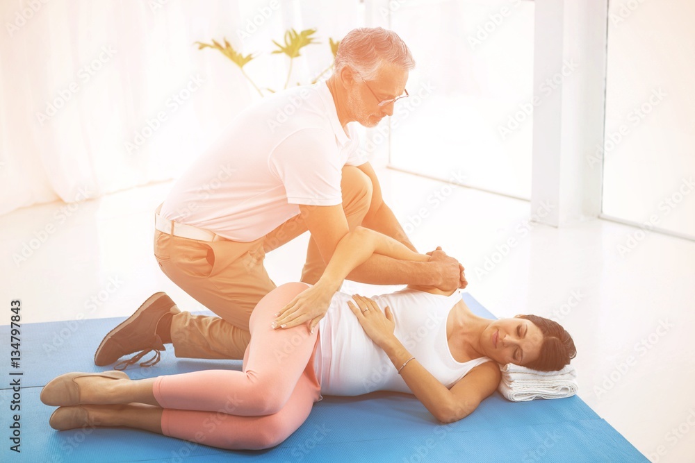 Doctor giving physiotherapy to pregnant woman