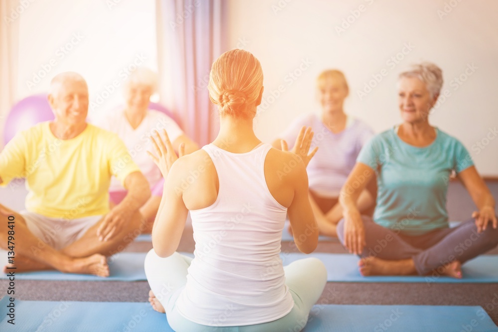 Instructor performing yoga with seniors