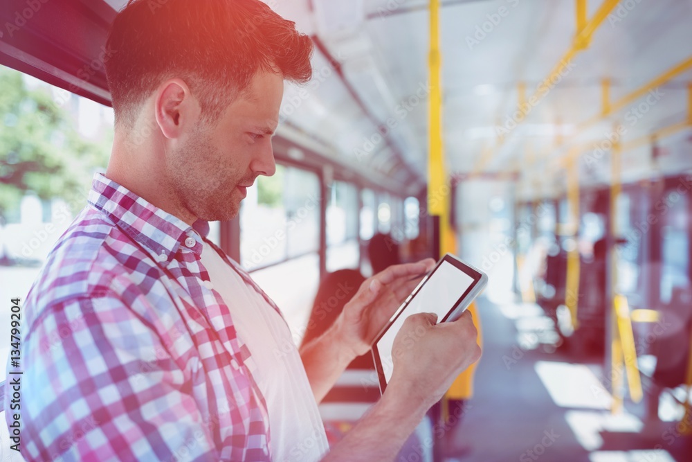 Handsome man looking at digital tablet in bus