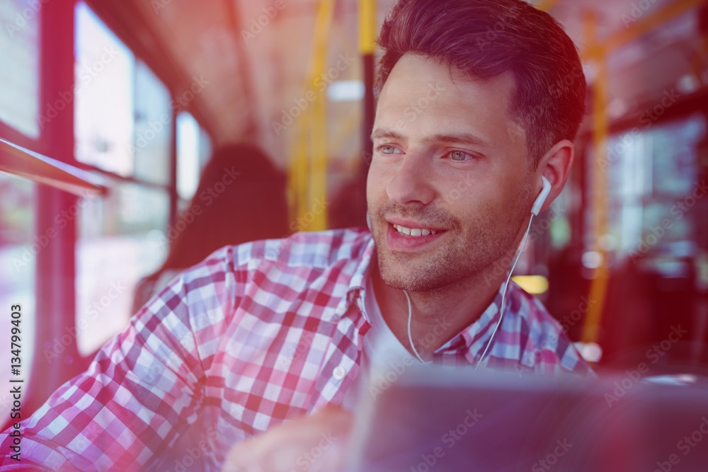 Handsome man listening music on digital tablet