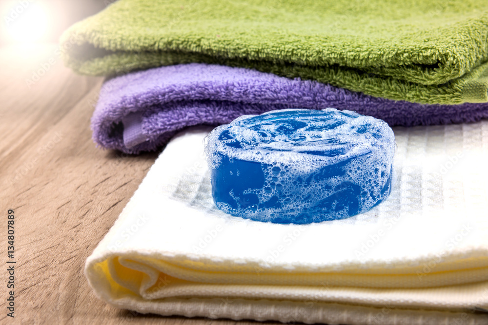 natural soap bar and bubble with bath towel on wooden background