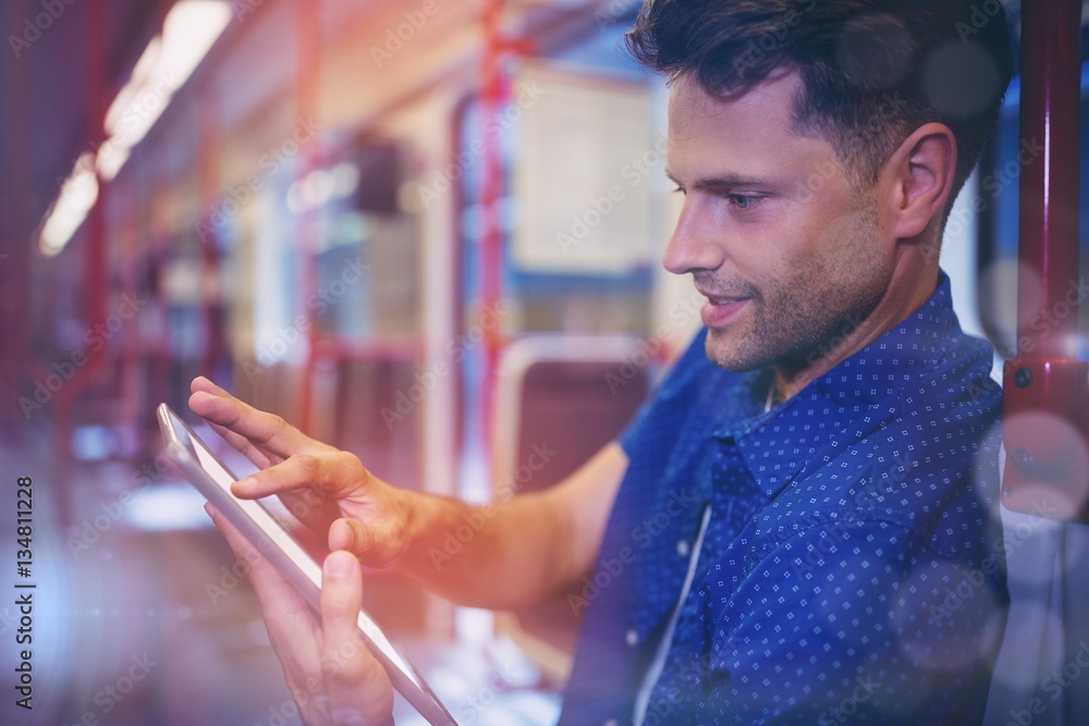 Close up of handsome man using digital tablet in train