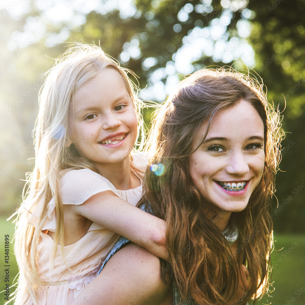 Sister Togetherness Outdoors Piggyback Concept