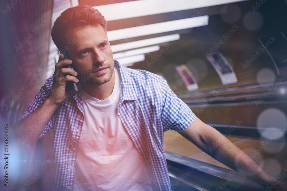 High angle view of handsome man using mobile phone on escalator